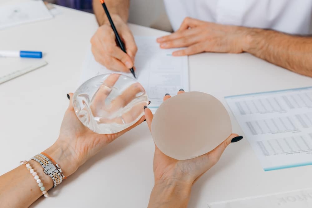 Woman holding breast implants planning her breast augmentation in Long Island, NY